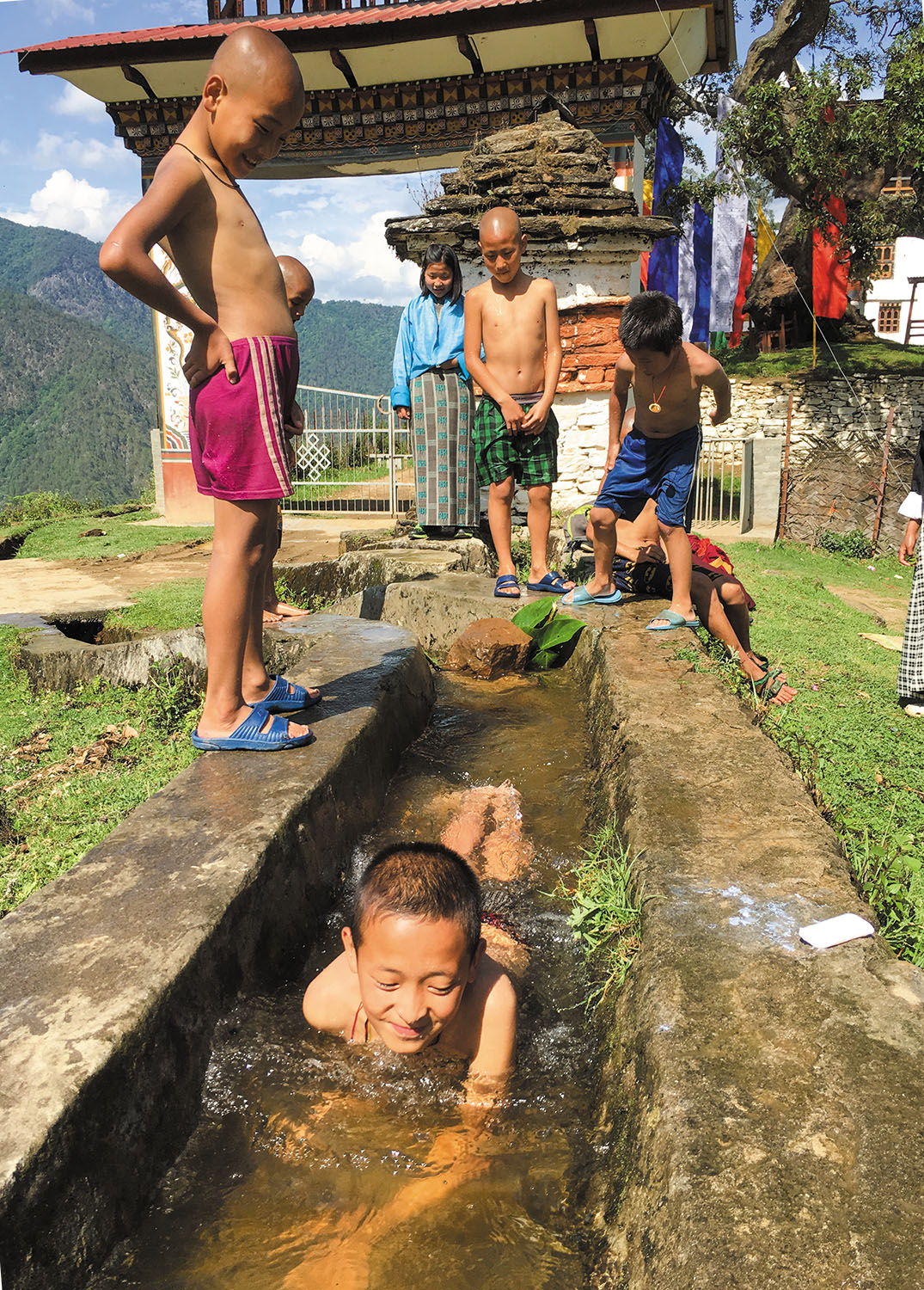 僧侶学校付近の水路で水遊びに興じる子どもたち。